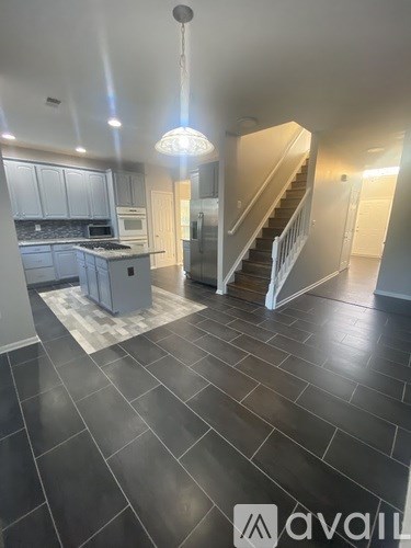 A modern kitchen with a staircase leading to the upper floor.