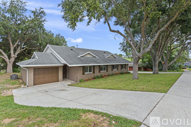 A house with a driveway and trees in front.