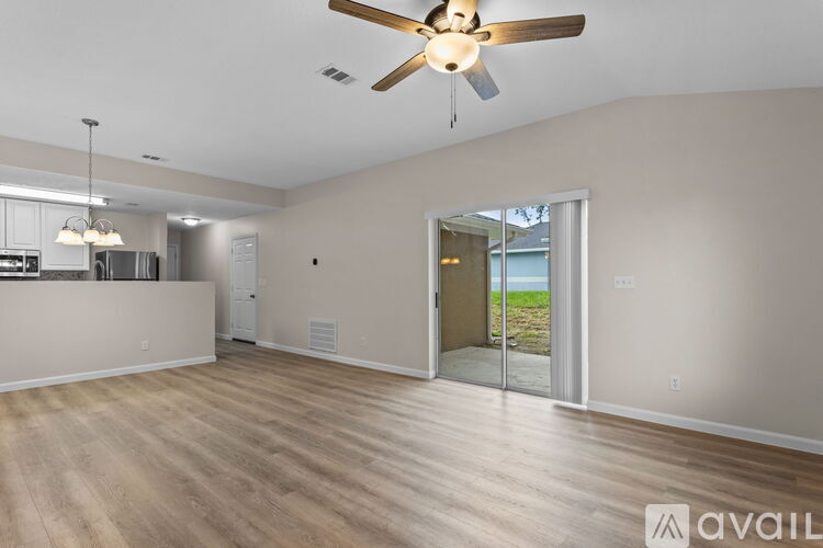 A spacious room with a ceiling fan and wooden flooring.
