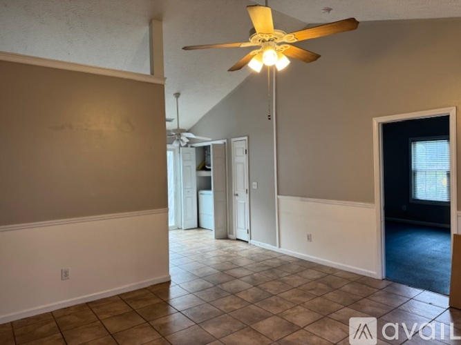 A room with a ceiling fan and tile flooring.