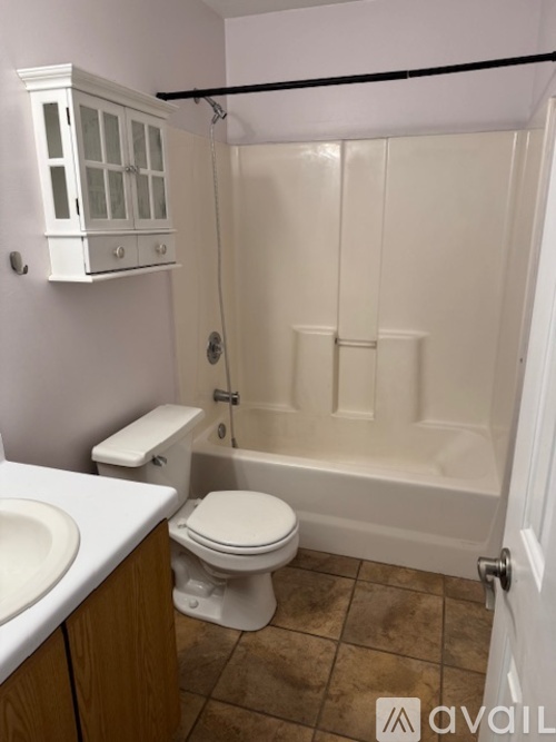 A white toilet sits next to a white sink in a bathroom.
