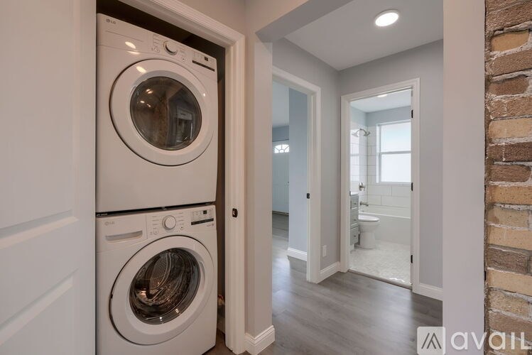 A washer and dryer are built into a wall in a laundry room.
