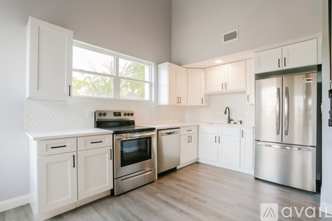 A kitchen with white cabinets and stainless steel appliances.