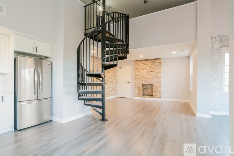 A spiral staircase in a modern home leads to a second floor.