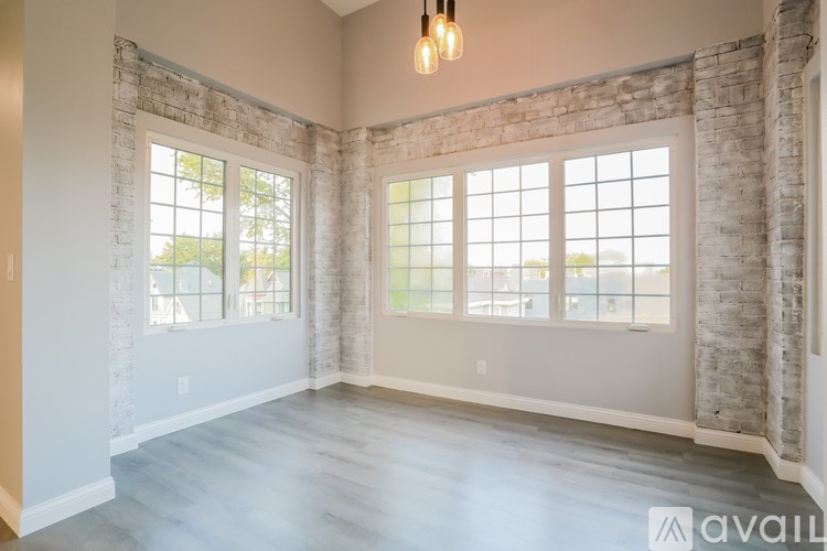 A room with a large window and a brick wall.