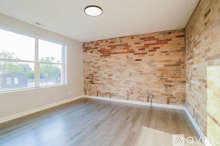 A room with a brick wall and wooden flooring.
