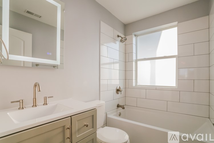 A bathroom with a white sink, toilet, and tub.