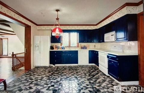 A kitchen with black and white tiles on the floor.
