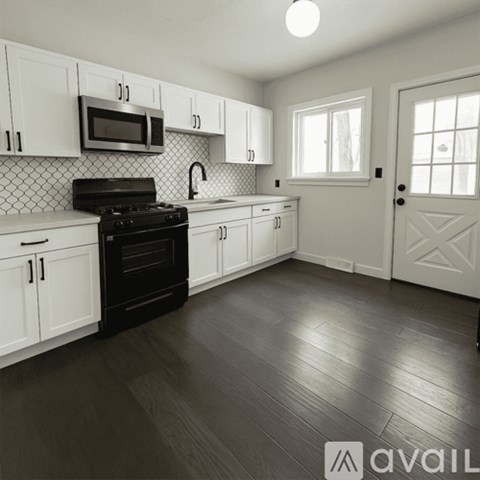 A kitchen with white cabinets and a black stove top oven.
