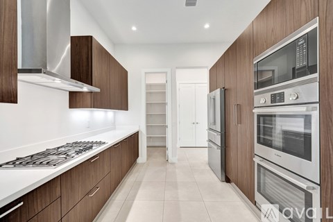 A modern kitchen with wooden cabinets and stainless steel appliances.