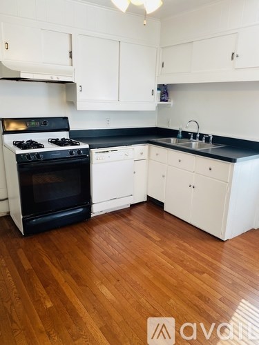 A kitchen with white cabinets and a black stove top oven.