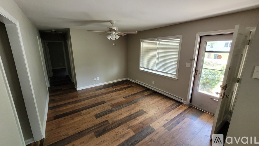 A room with wooden flooring and a ceiling fan.