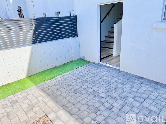 A white building with a blue door and steps leading up to it.