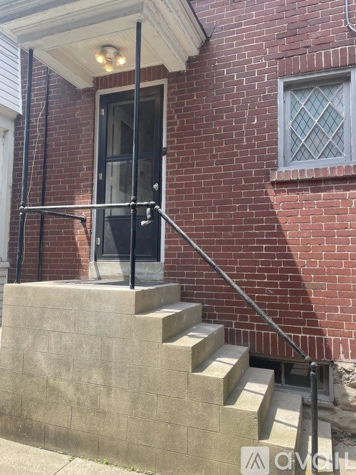 A brick house with a black door and a window.