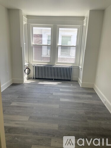A room with a window and a radiator on the floor.