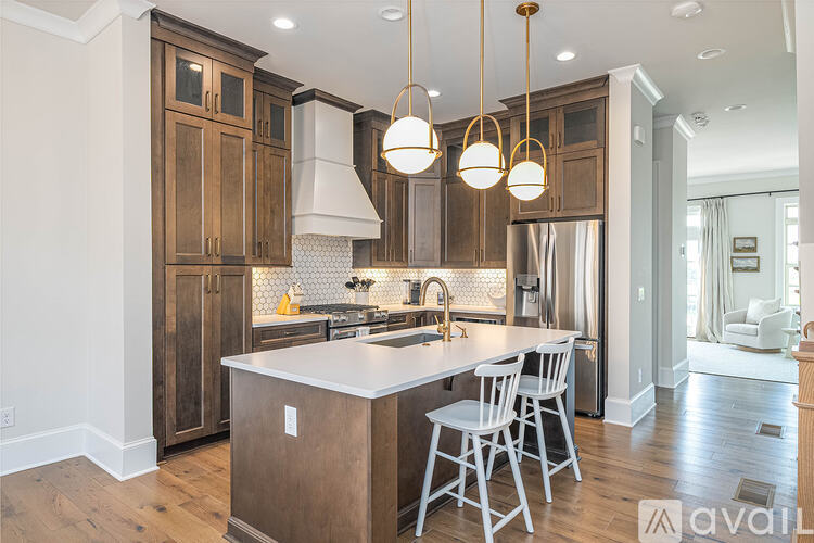 A kitchen with wooden cabinets and a white island.