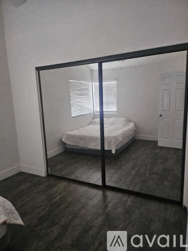 A bedroom with a bed and a mirror on the wall.