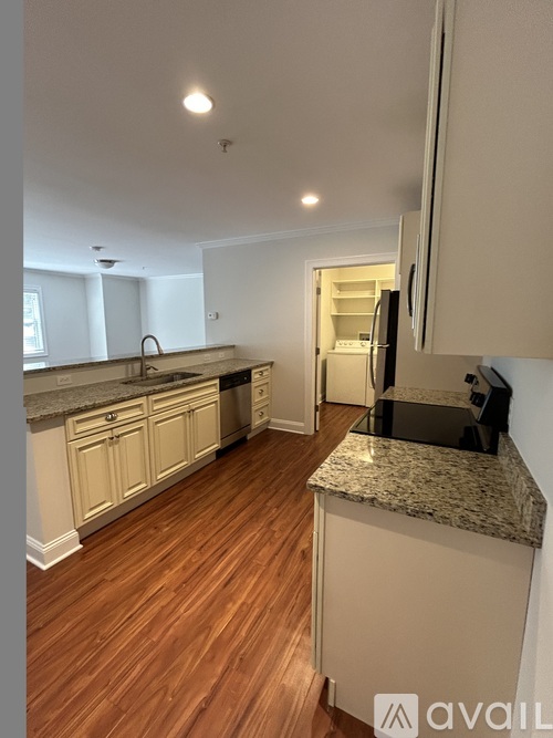 A kitchen with wooden floors and white cabinets.