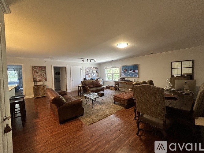 A living room with a brown couch and a wooden floor.