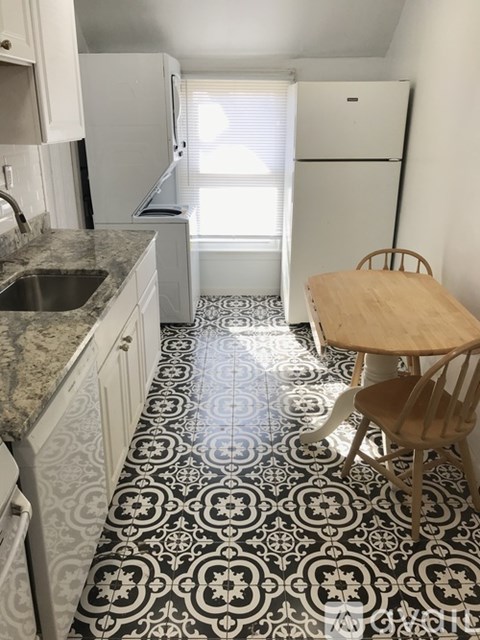 A kitchen with a table and chairs.