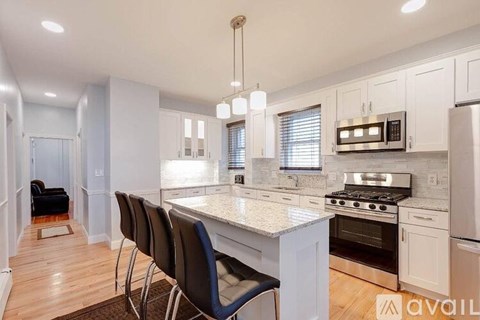 A kitchen with white cabinets and a marble countertop.