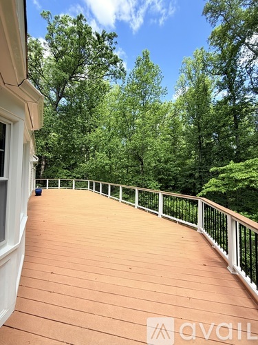 A deck with a railing and trees in the background.
