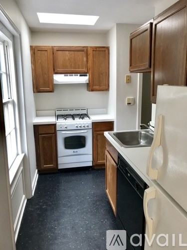 A kitchen with wooden cabinets and a white fridge.