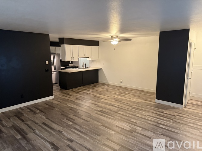 A spacious room with a kitchen area in the background.