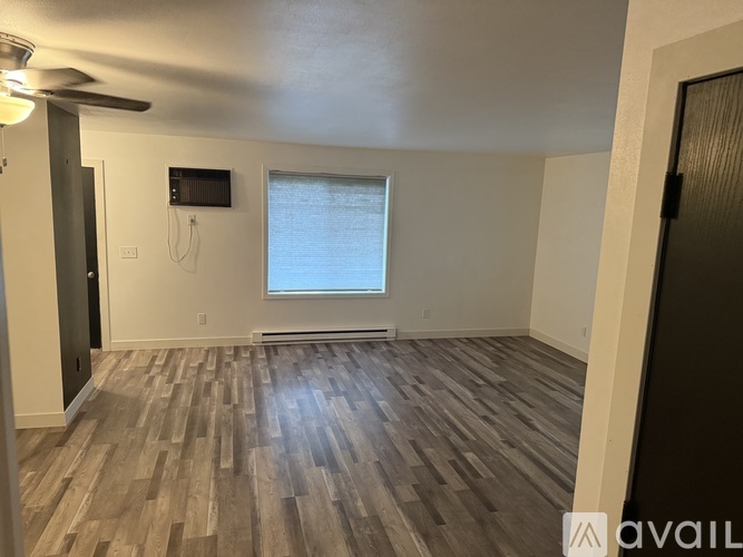 A room with wooden flooring and a window.