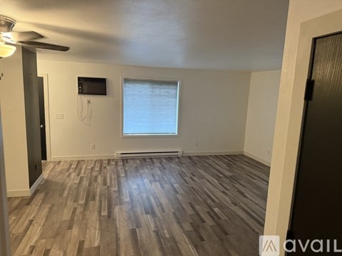 A room with wooden flooring and a window.