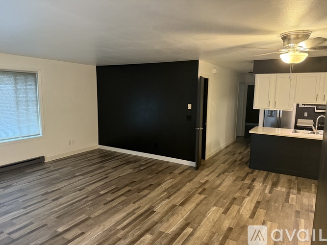 A room with wooden flooring and a black wall.