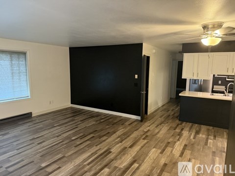 A room with wooden flooring and a black wall.