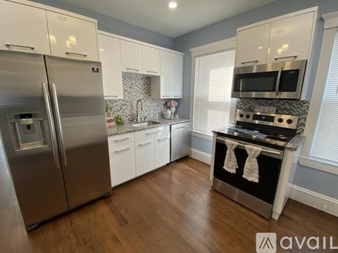 A modern kitchen with a stainless steel refrigerator and oven.