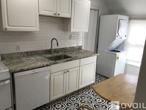 A kitchen with white cabinets and a black and white floor.