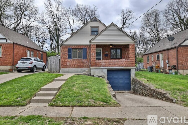 A house with a garage and a car parked in front.