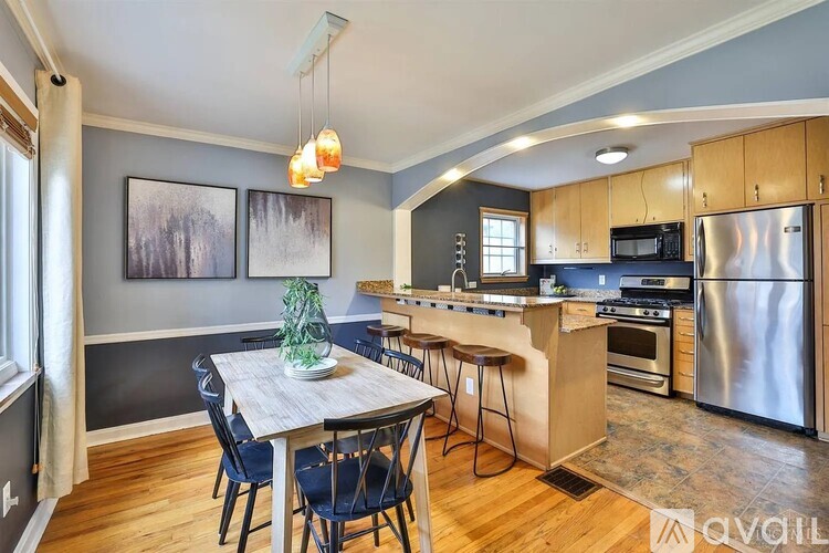 A kitchen with a dining table and chairs.