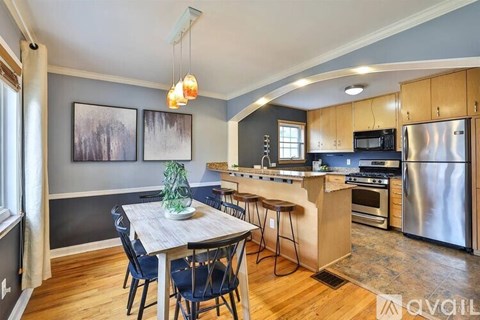 A kitchen with a dining table and chairs.