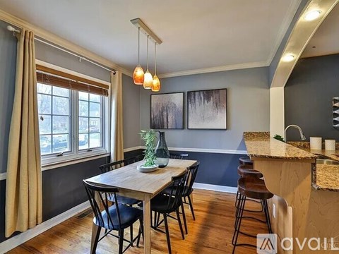 A dining room with a wooden table and chairs.