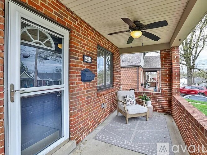 A balcony with a chair and a ceiling fan.