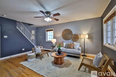 A living room with a blue wall and a wooden floor.