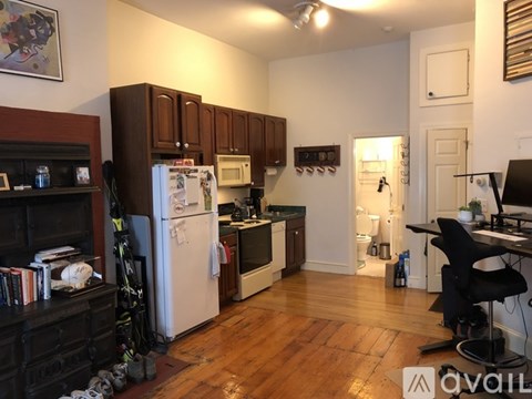 A kitchen with wooden floors and white appliances.