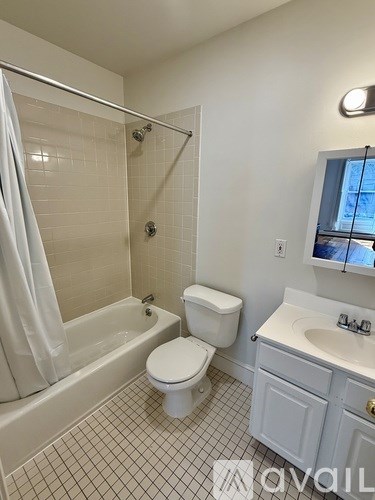 A white toilet sits next to a bathtub in a bathroom.