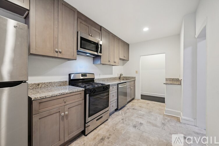 A kitchen with a refrigerator, oven, and microwave.