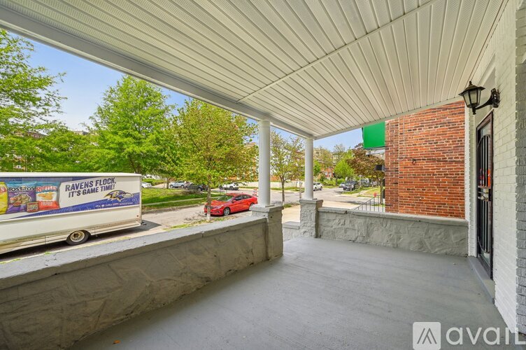 A covered walkway with a white ceiling and a brick building on the right.