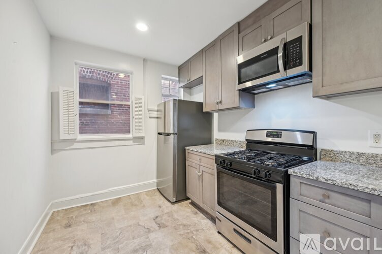 A kitchen with a stainless steel refrigerator, oven, and microwave.
