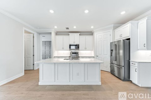 A kitchen with white cabinets and a large island.