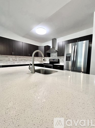 A modern kitchen with a granite countertop and stainless steel appliances.