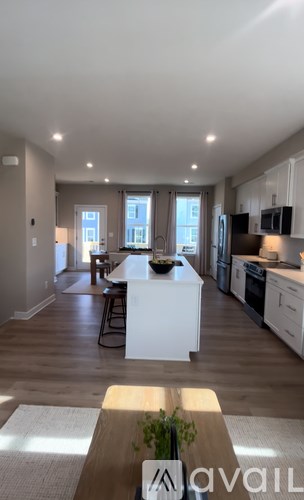 A modern kitchen with white cabinets and a wooden island.