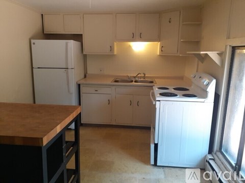 A kitchen with a white fridge, stove and oven.