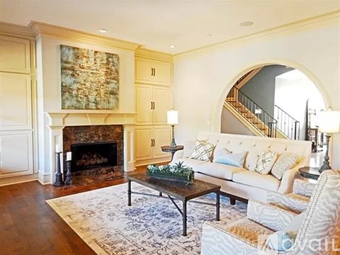 A living room with a fireplace and a painting on the wall.